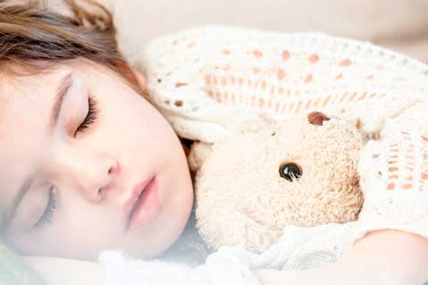 kid sleeping with teddy bear